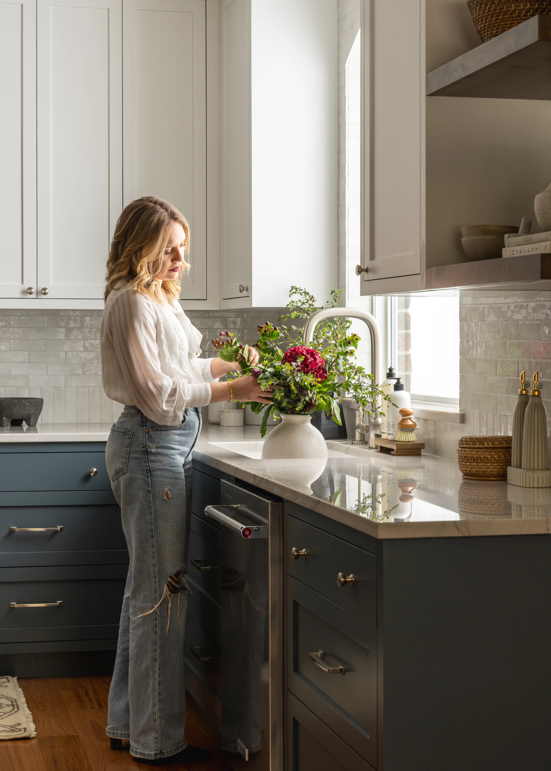 Julia Harrison arranging flowers at the kitchen sink