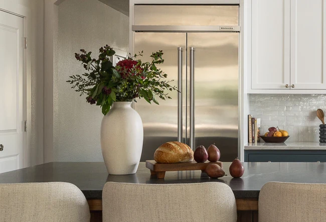 Vase of garden flowers and a bread board staged on the Virginia Mist island