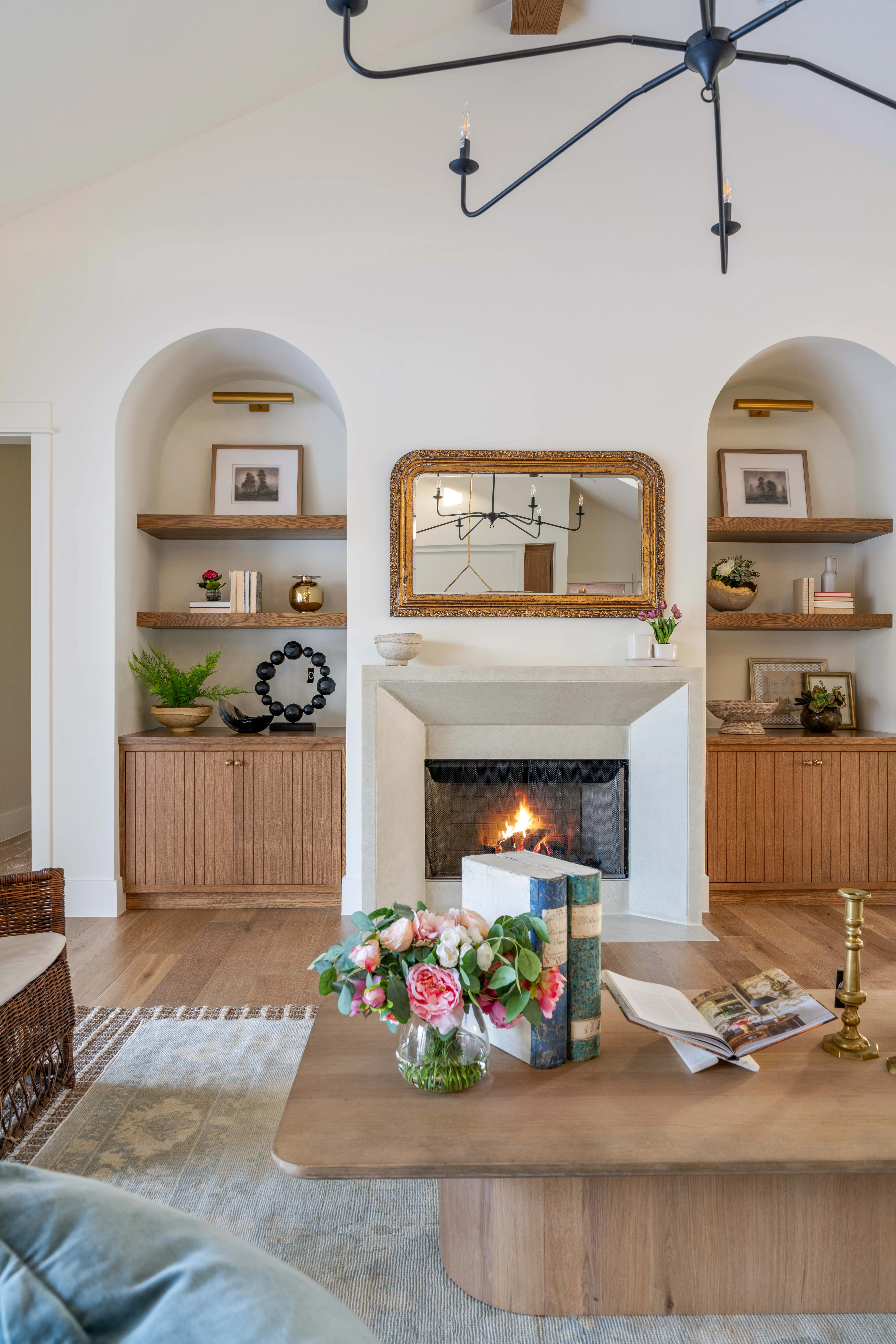 Plaster fireplace flanked by arched built-in niches in the great room