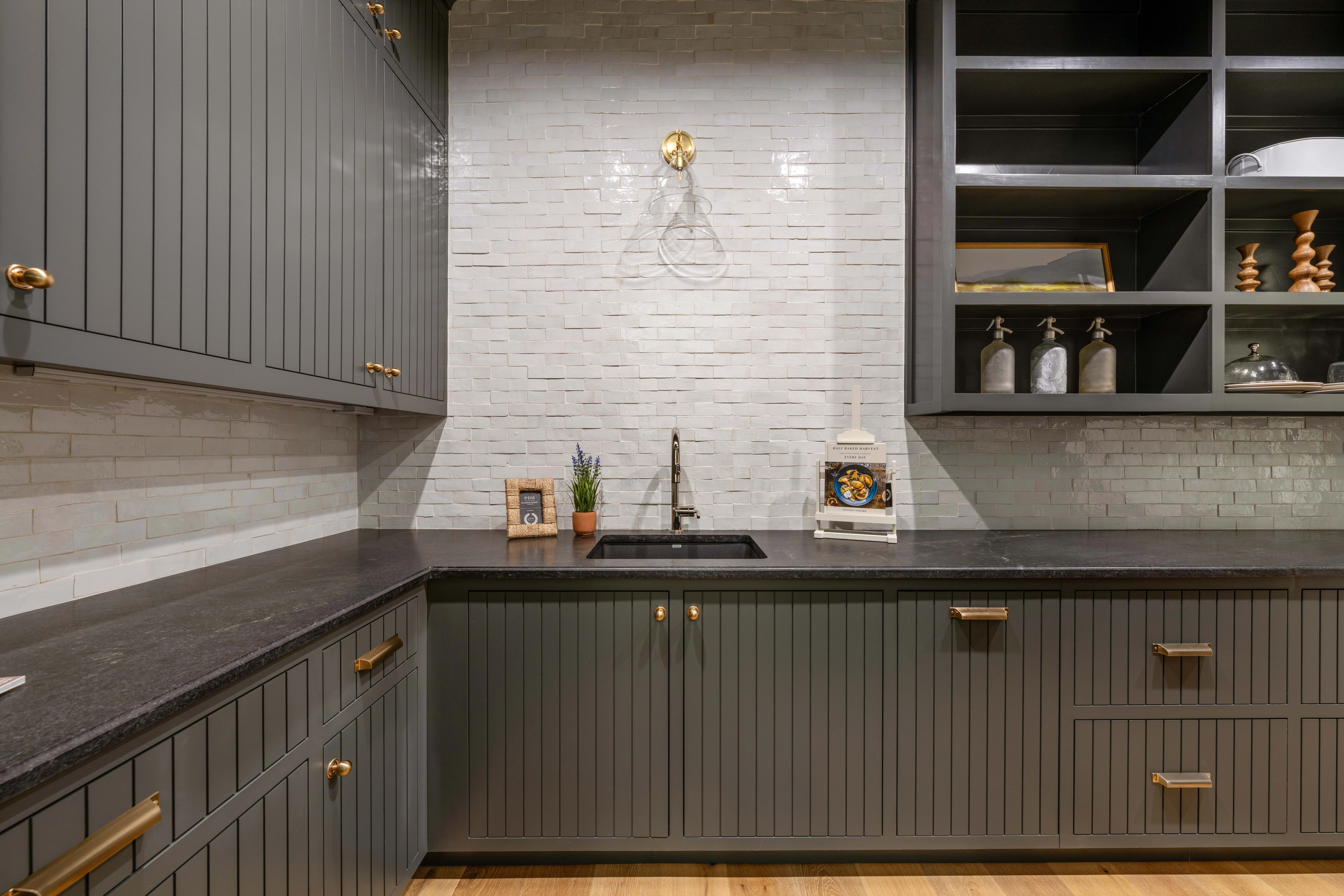 Open timber shelf styled with art and ceramics above the marble counter