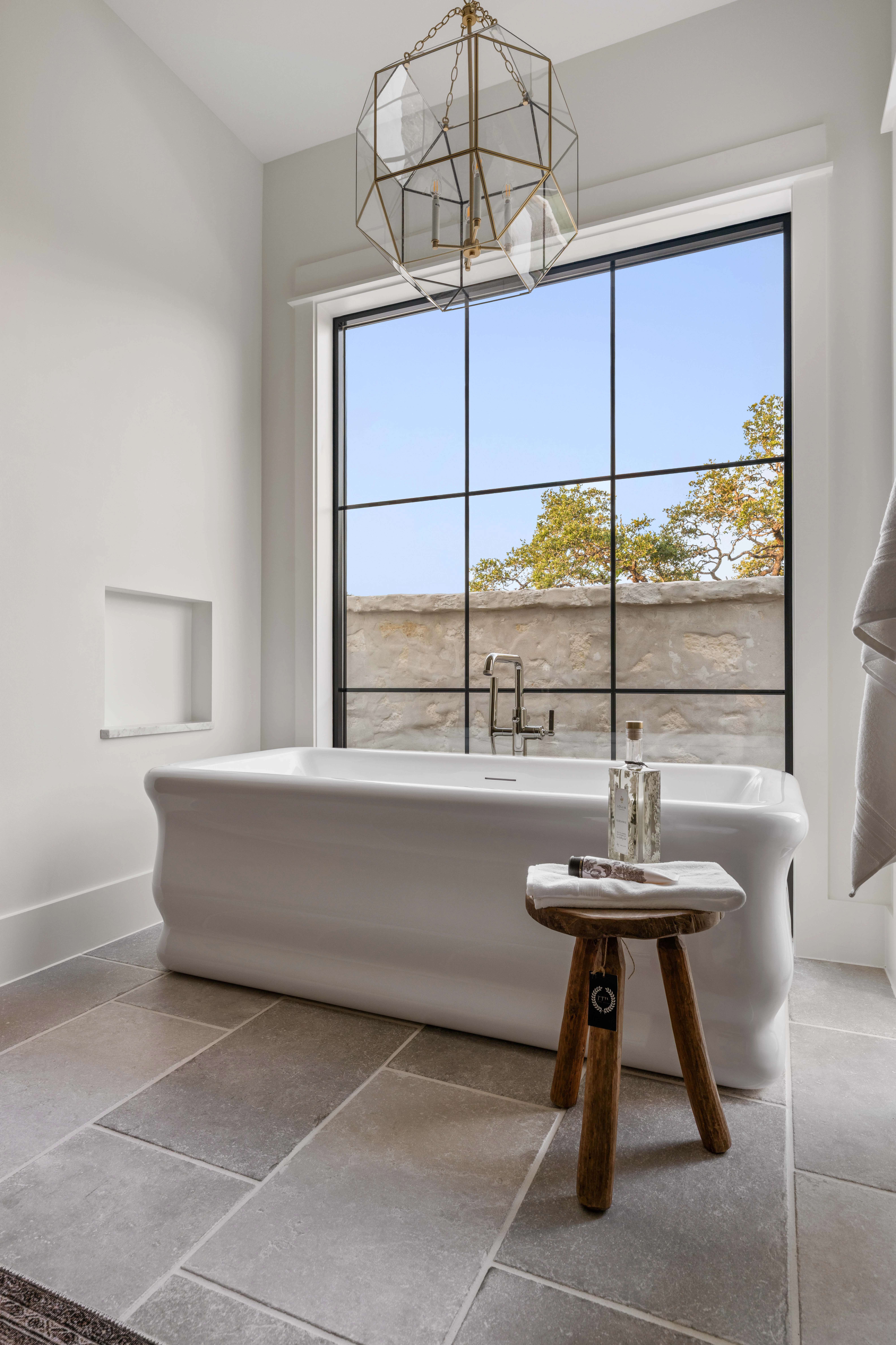 Tub set against the steel window with a timber stool