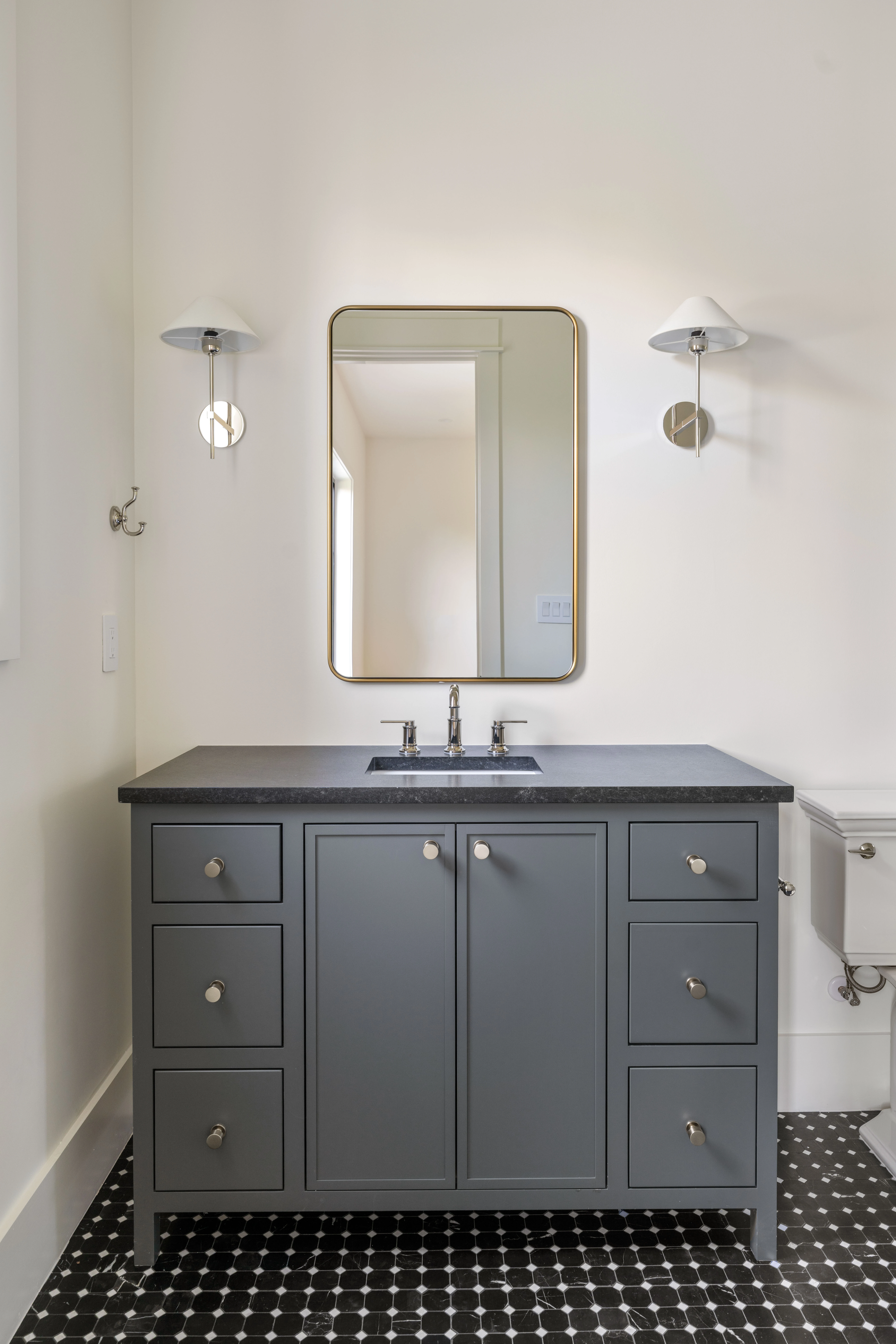 Charcoal vanity with a Black Mist top and penny-tile floor