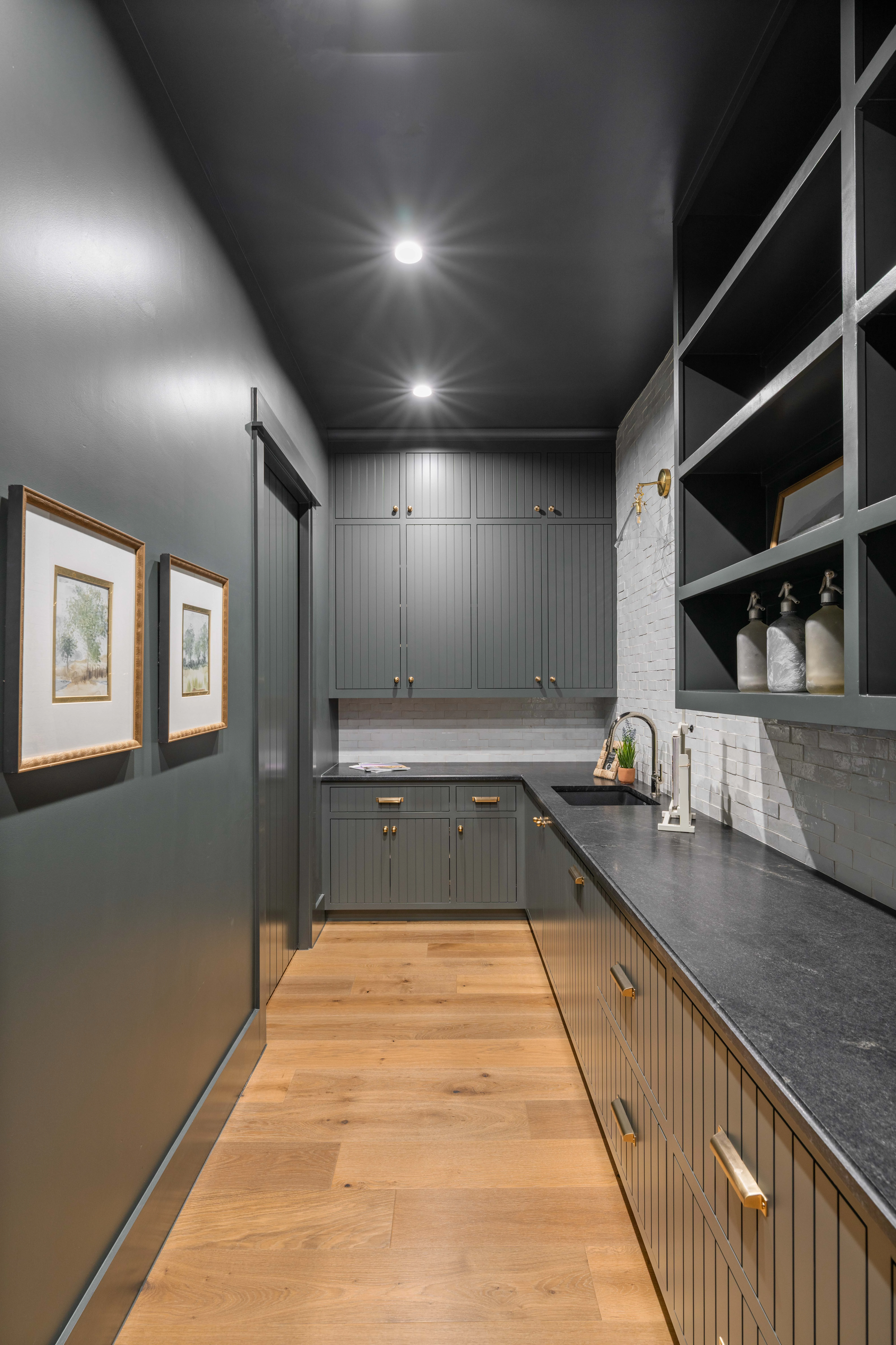Charcoal pantry corridor with open shelving and a dark stone worktop