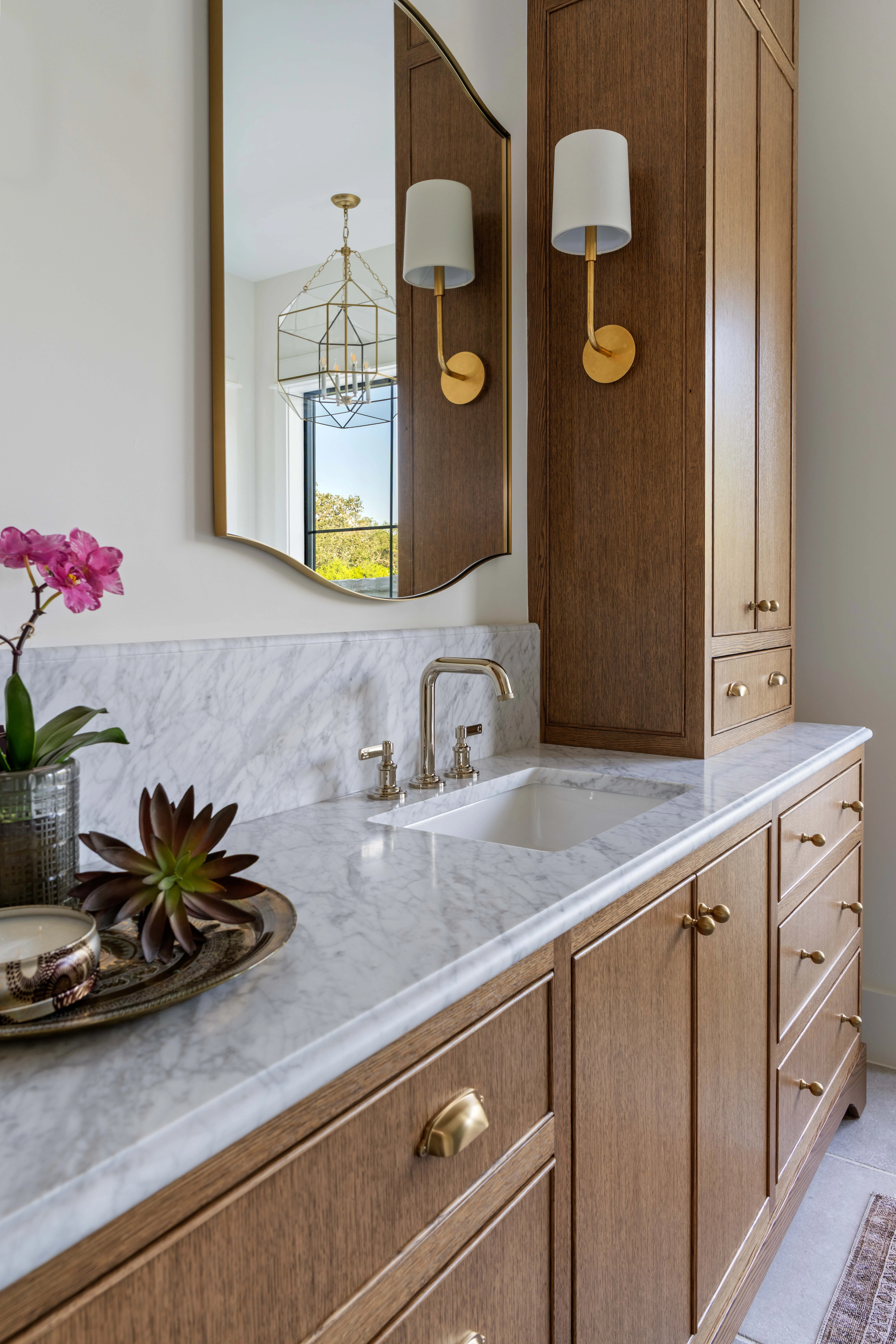 Orchid and a shallow bowl on the marble powder-room vanity