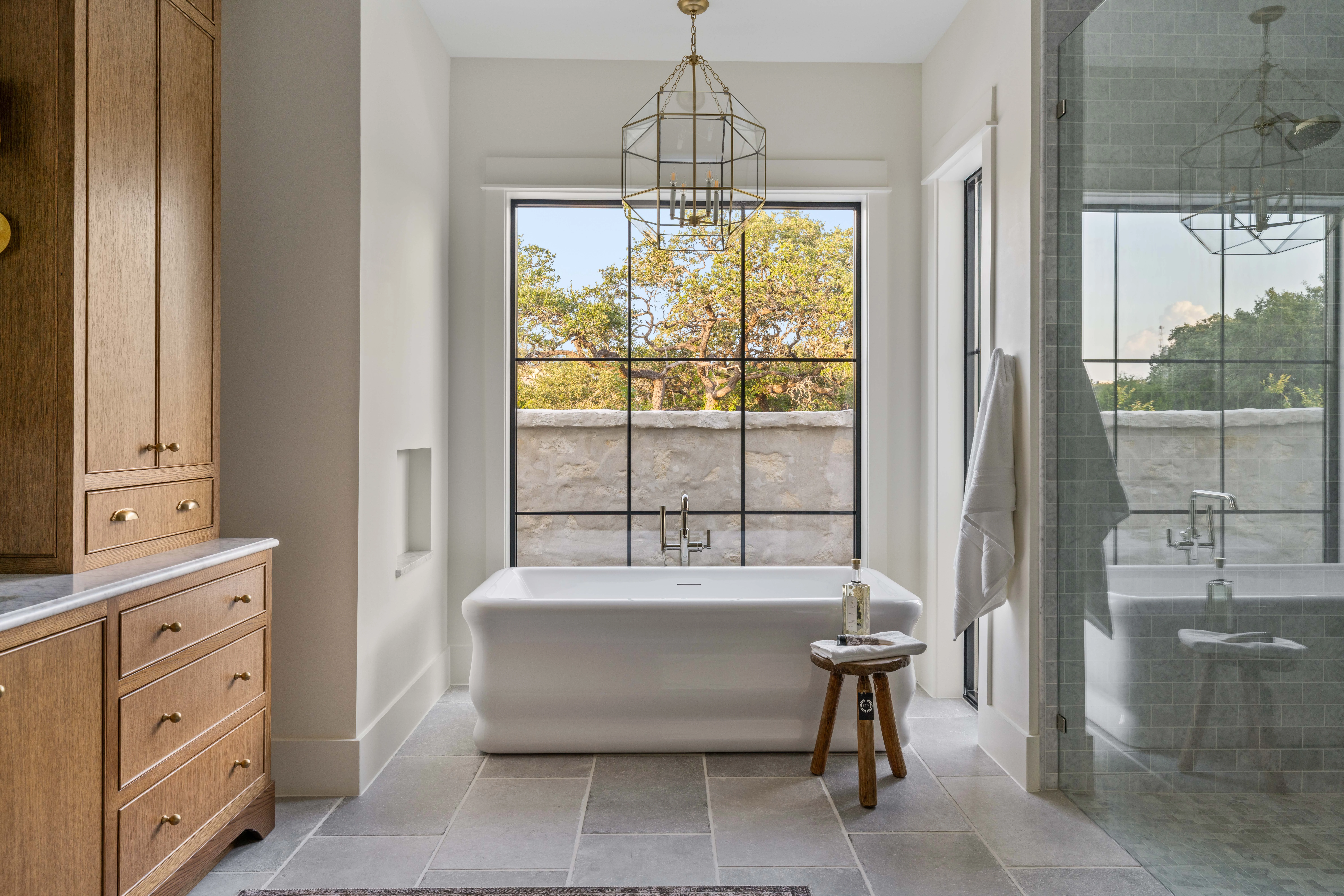 Freestanding tub beneath a black steel window