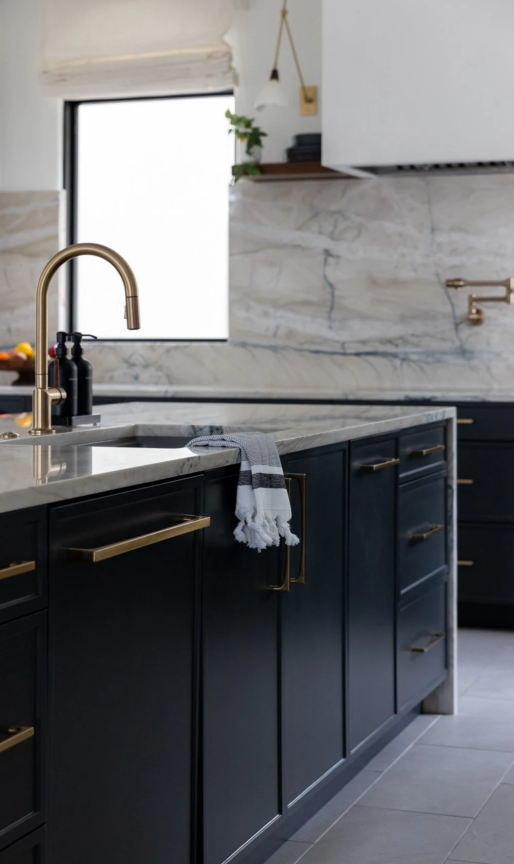 Gold faucet and striped towel at the island sink