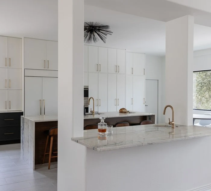 The kitchen seen from the dining room, island and range wall in view