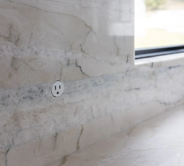 Outlet set flush into the quartzite backsplash veining