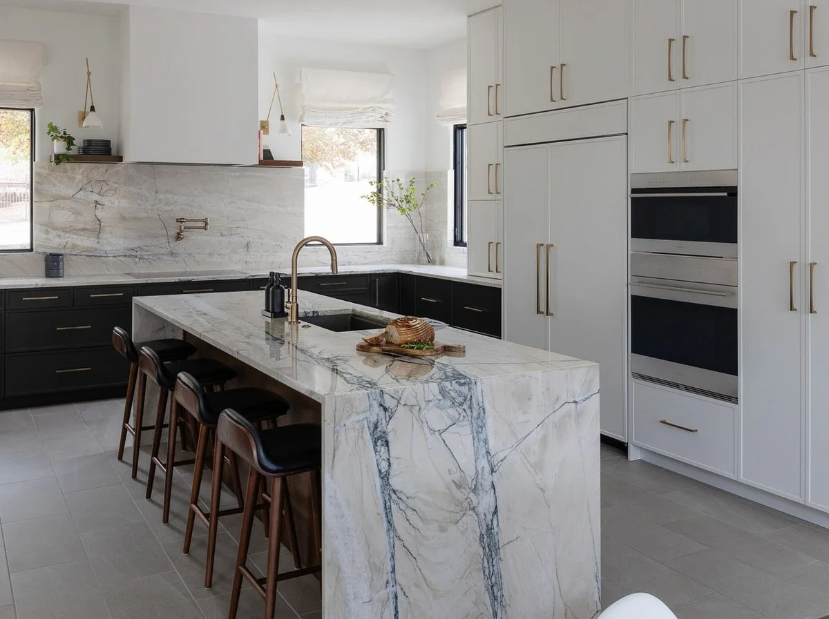 Fantasy Lux quartzite waterfall island with walnut counter stools in a white and black Austin kitchen