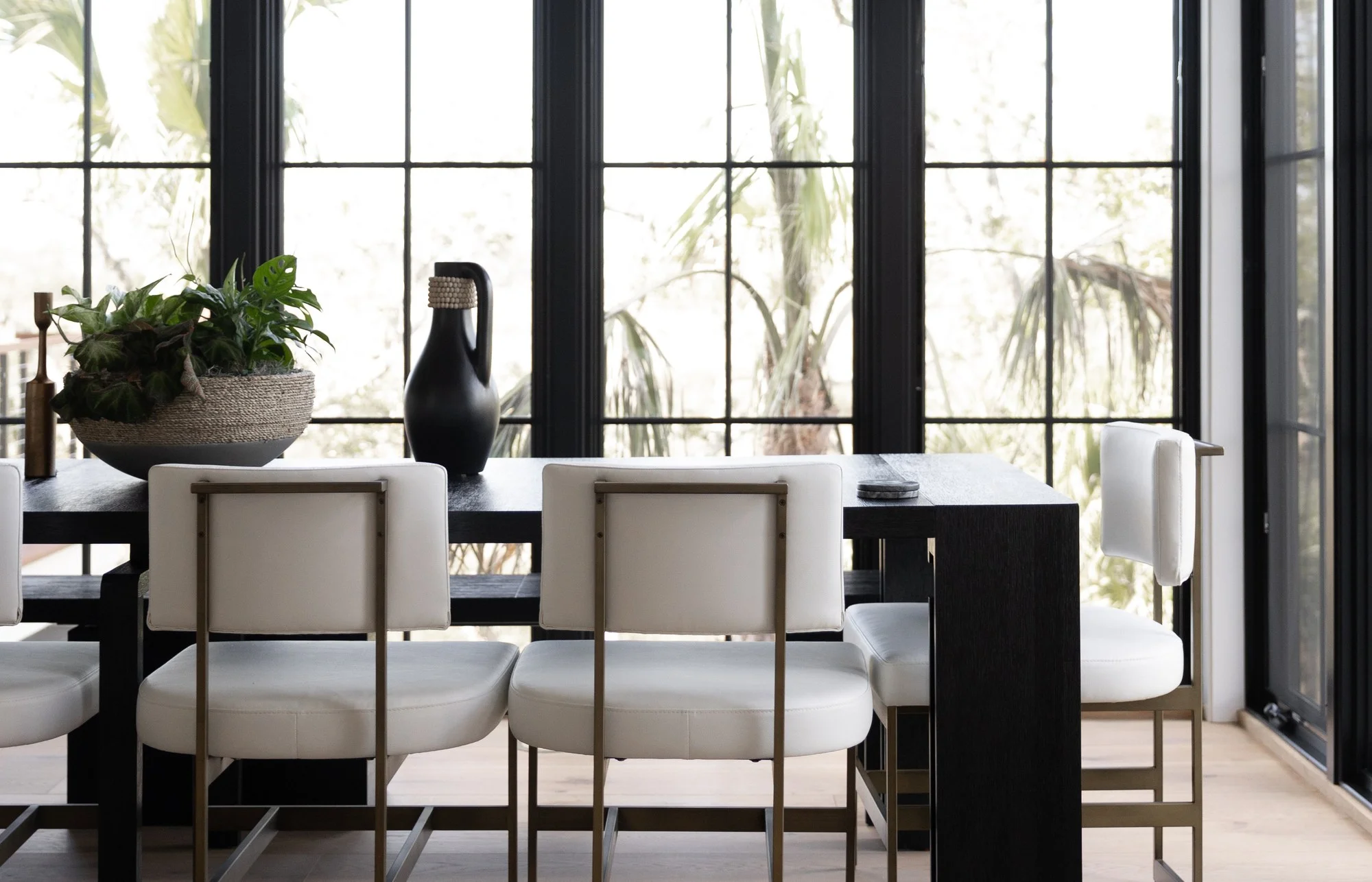 Houston dining room framed by tall black-framed windows