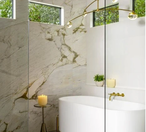 Marble surround and brass fittings beside the tub