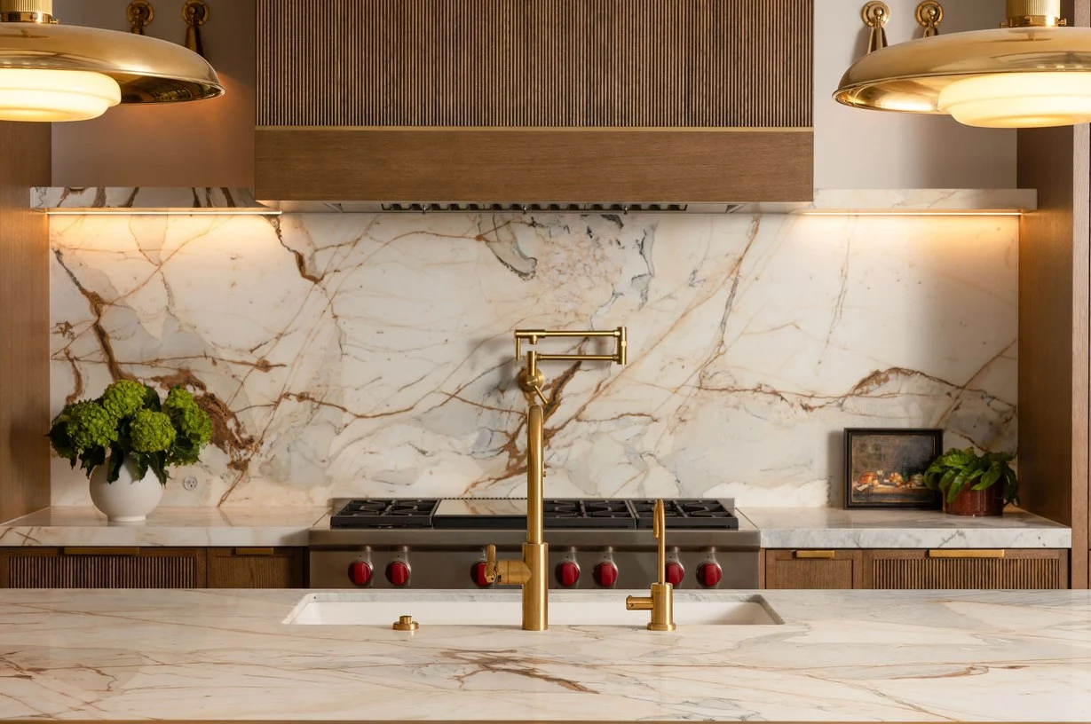 Calacatta Picasso island with brass fittings and a walnut range wall