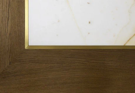 Brass reveal between the walnut overhang and the Picasso marble
