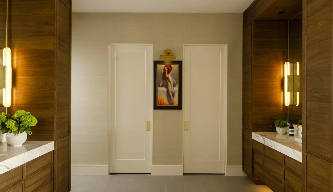 Walnut hallway lit by slim brass sconces