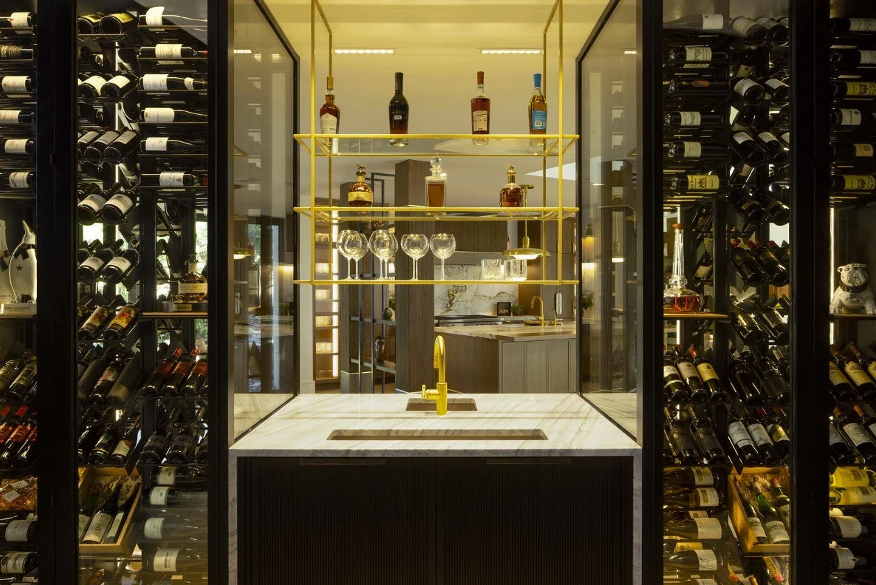 Two-sided steel and glass wine enclosure between the kitchen and game room