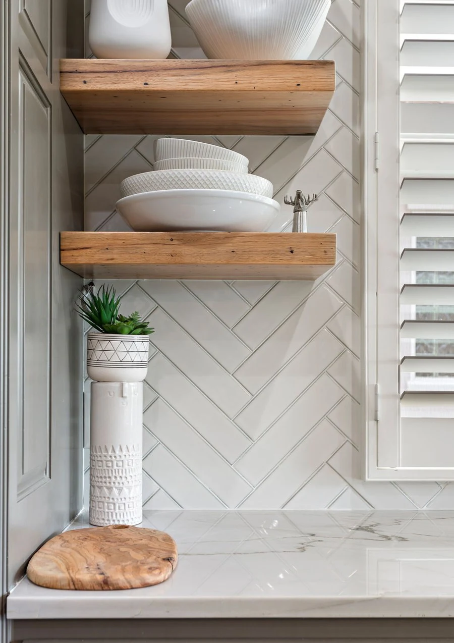 Open timber shelving stacked with pale ceramics
