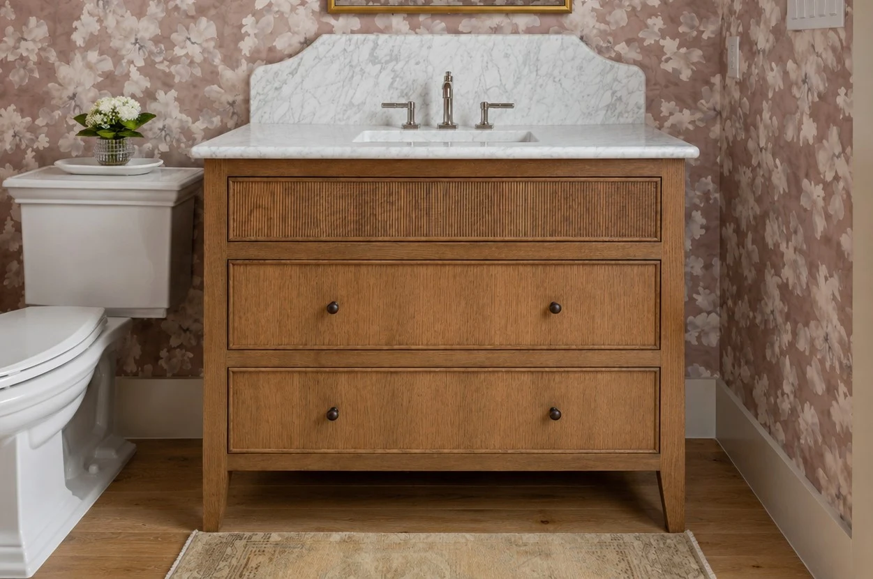 Powder room with floral wallpaper and a marble-topped oak vanity