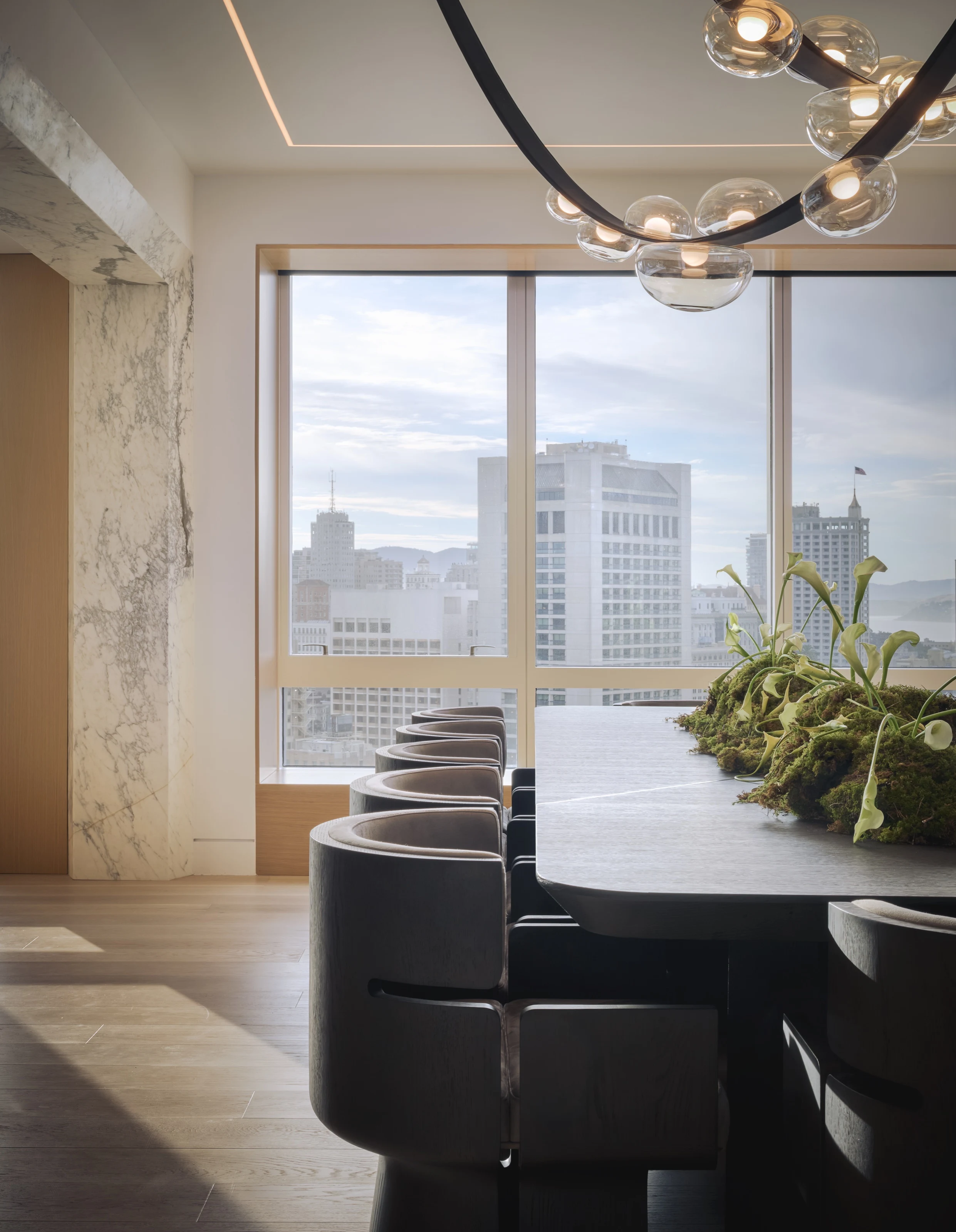 Dining table running to a window over the city, a moss runner down its center