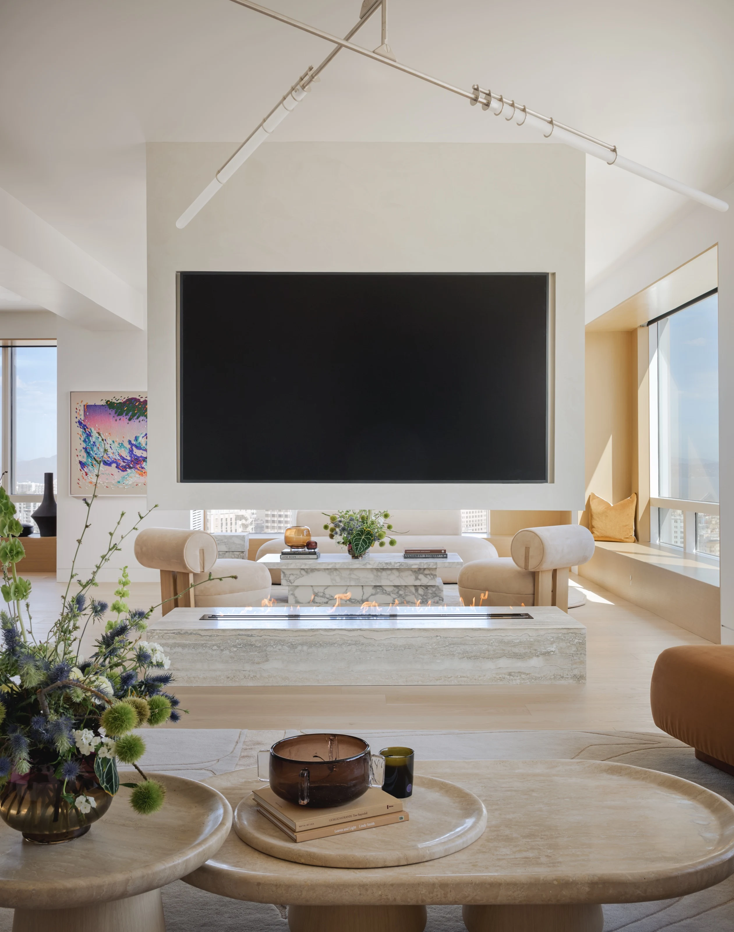 Living room with a Travertino Alabastrino fireplace bench beneath a wall-mounted screen