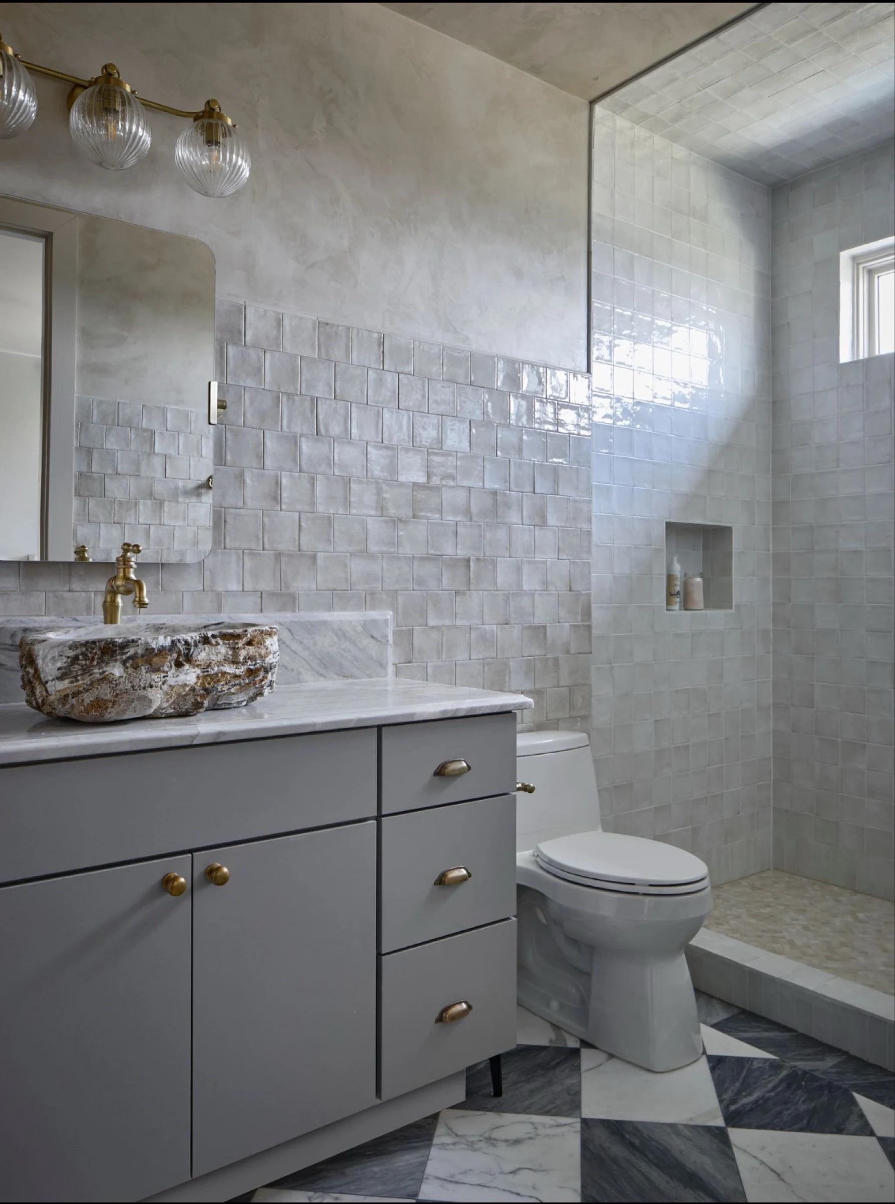 Guest bath with a stone vessel sink, brass tap and glazed white tile