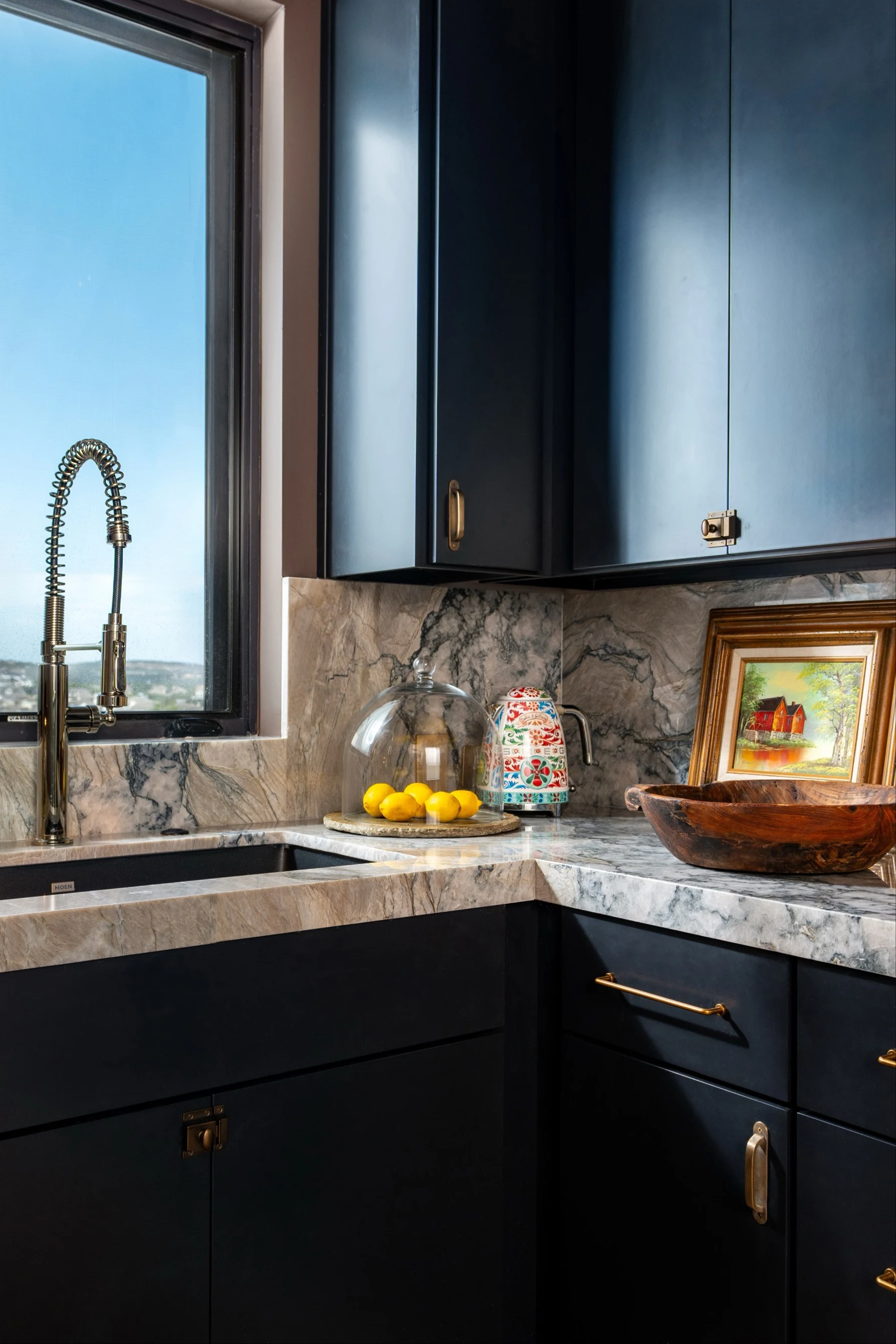 Poseidon quartzite counter and backsplash in the pantry corner, under black cabinets