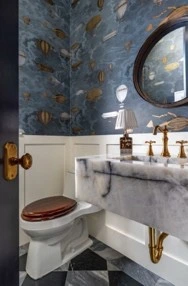 Powder room with a marble sink and blue fish-patterned wallpaper
