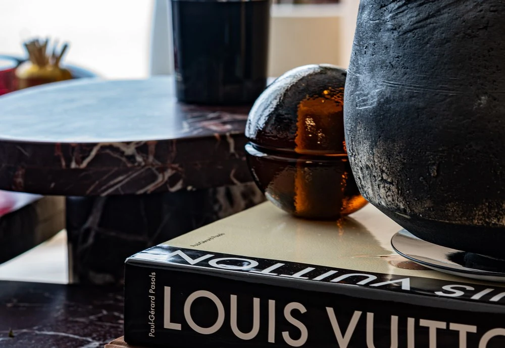 Art books and an amber vessel on a marble table