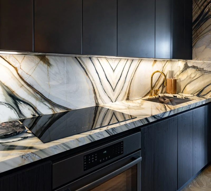 Chevron-matched Calacatta Fabricotti backsplash above the cooktop