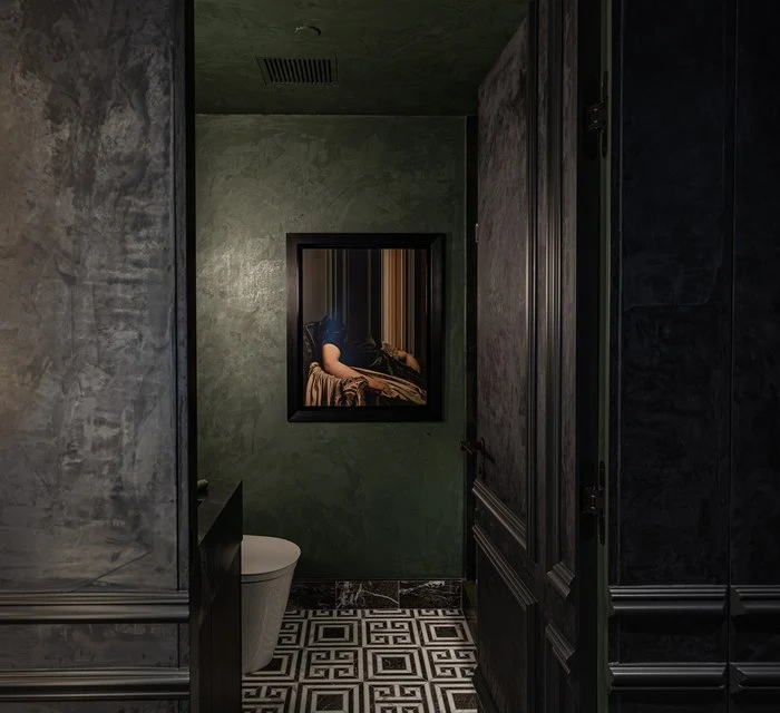 Doorway into the deep green primary bath