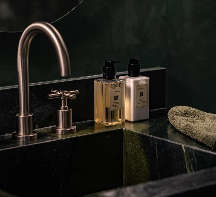 Brass cross-handle faucet on the green stone vanity