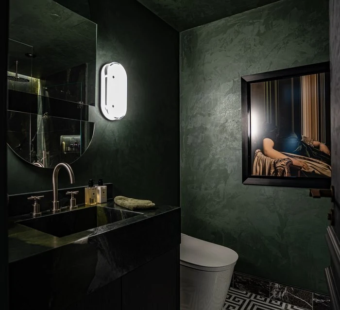 Mirror and sconce above the green stone basin