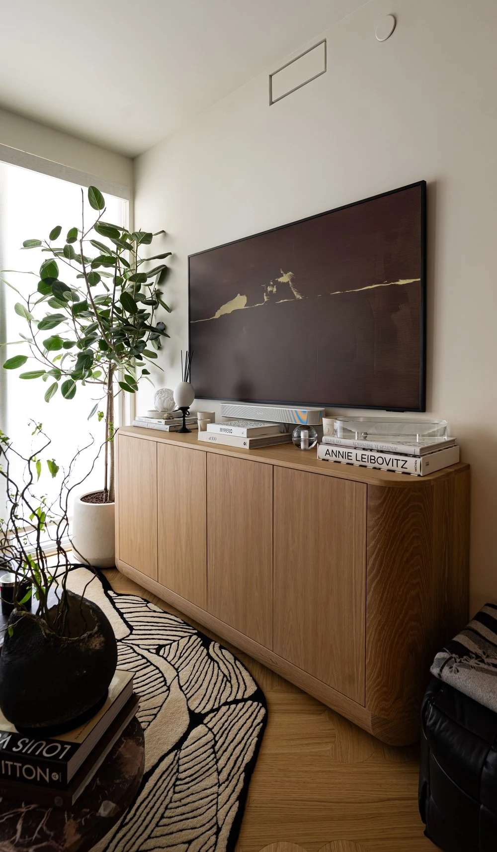 Oak credenza, fiddle-leaf fig and framed artwork