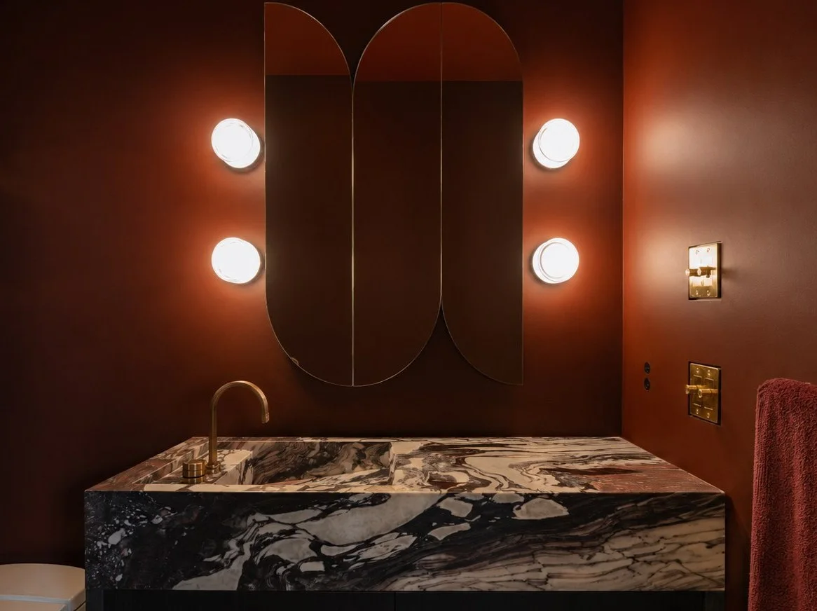 Calacatta Viola vanity and arched mirrors in an oxblood powder room
