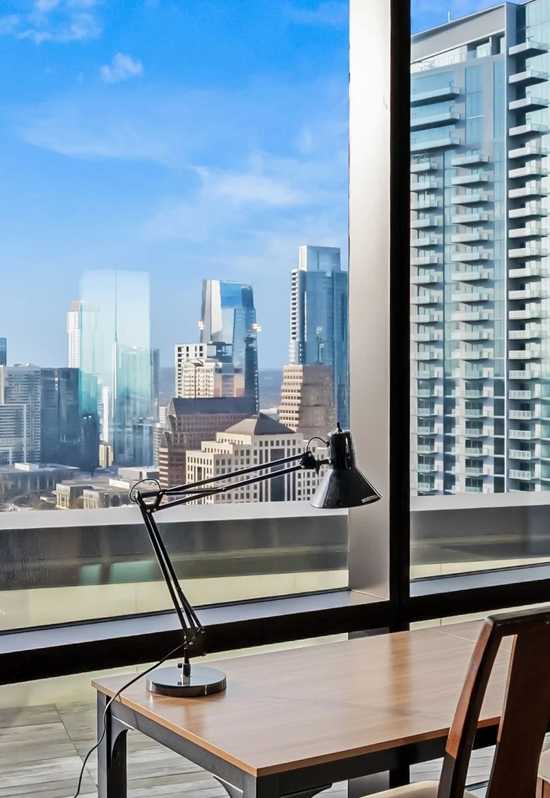 Desk and task lamp against the skyline window