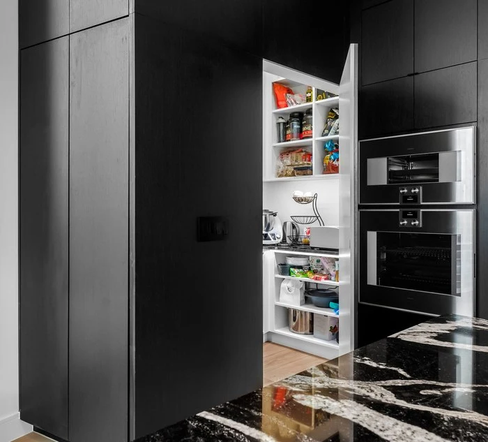 The walk-in pantry concealed behind the cabinetry wall