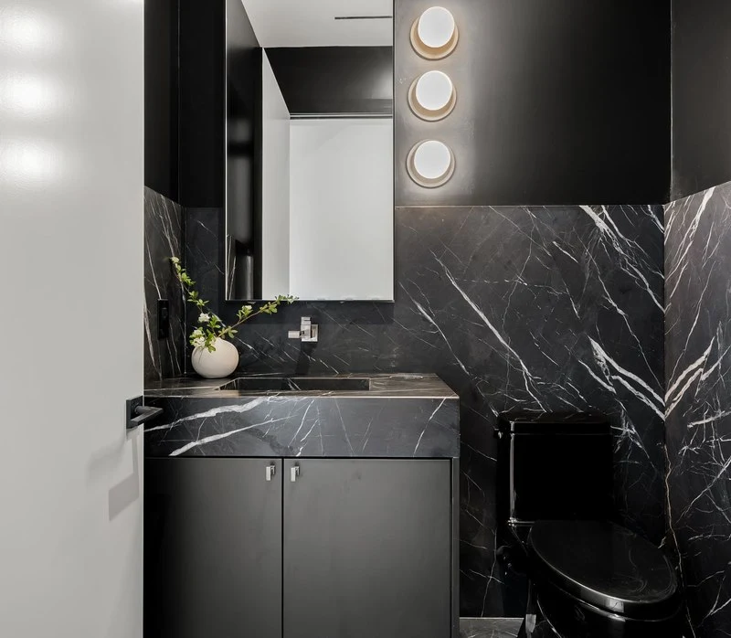 Powder room clad in black veined stone
