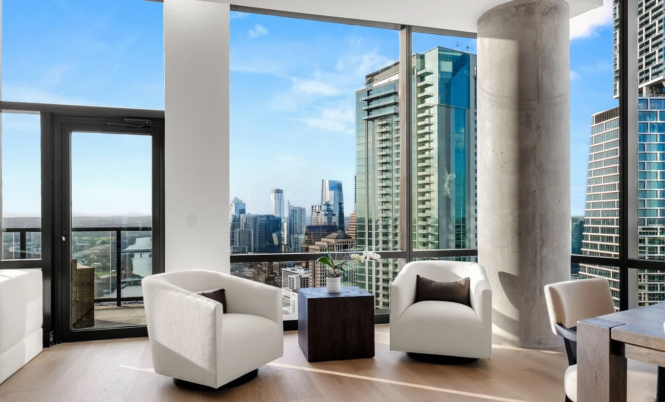Swivel chairs by the balcony door and the concrete column