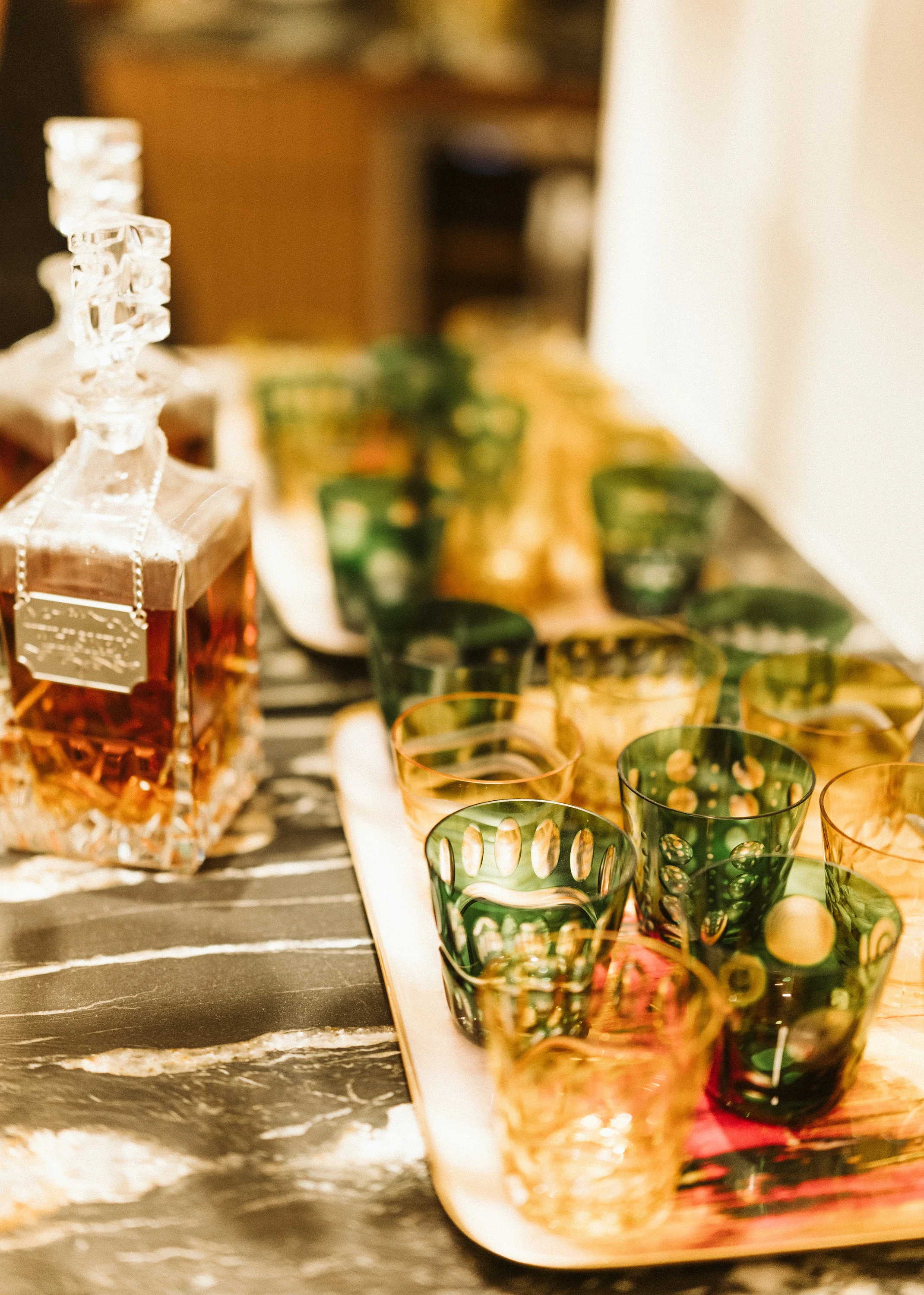 Cut-glass decanter and coloured glassware on a tray