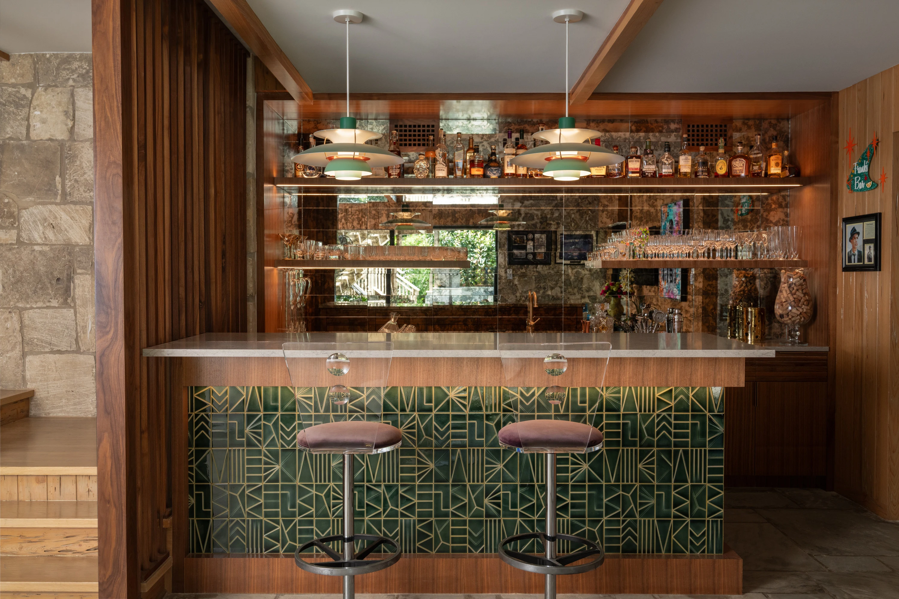 Green-tiled bar with counter stools and timber cabinetry