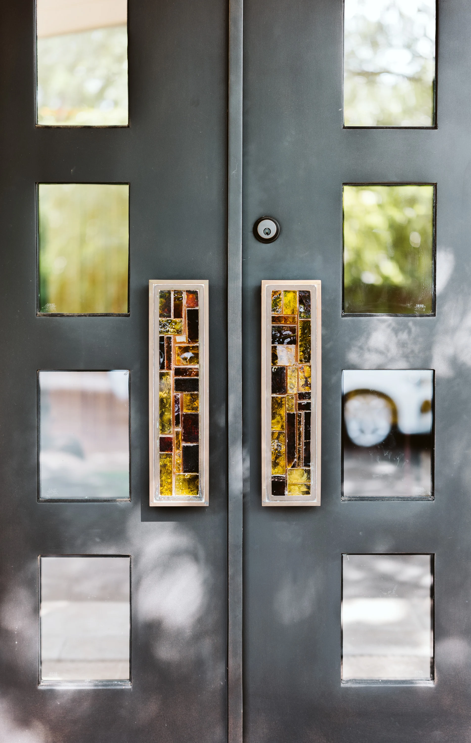Dark steel entry doors set with textured glass panels