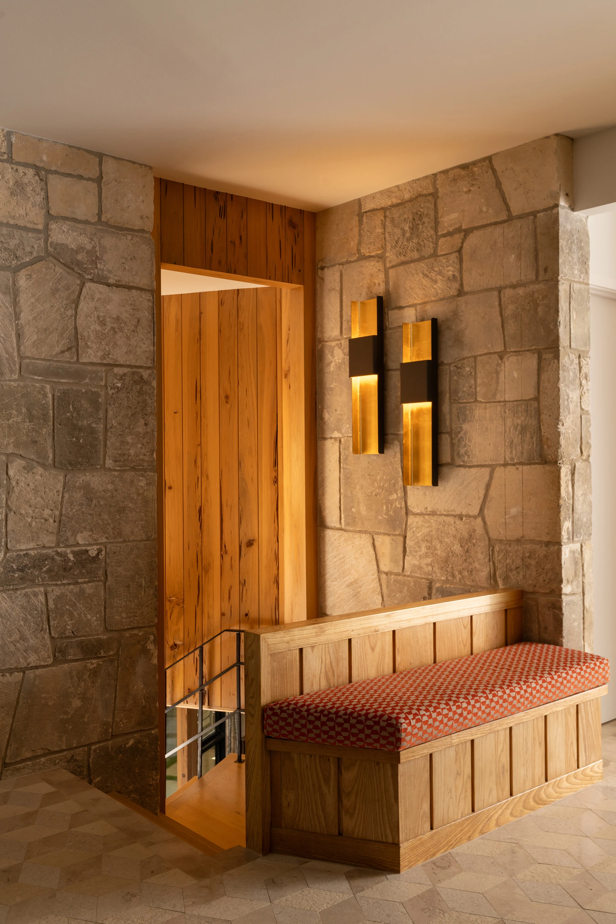 Timber bench set into the stone wall of the hall