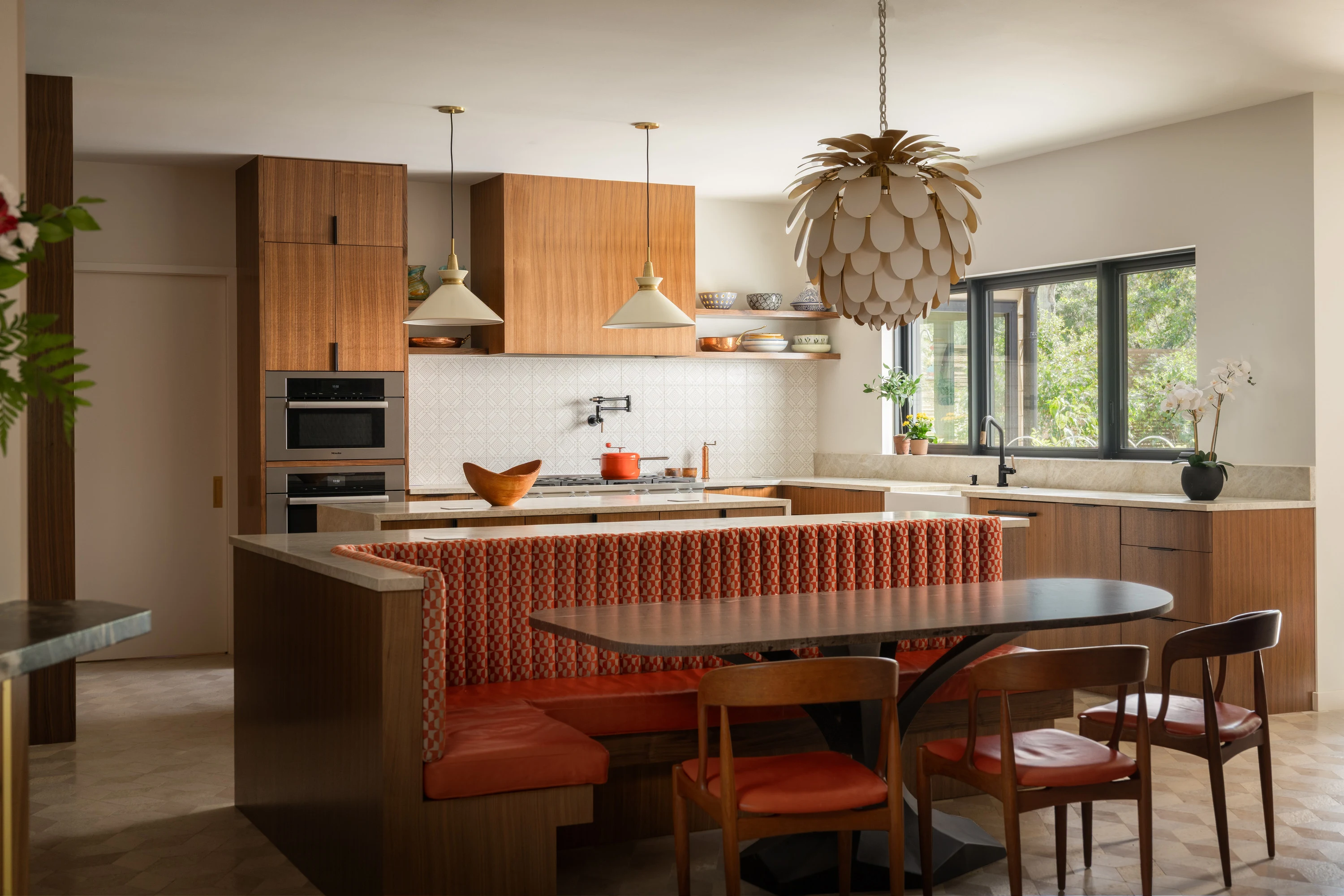 Kitchen island and banquette seating under a woven pendant