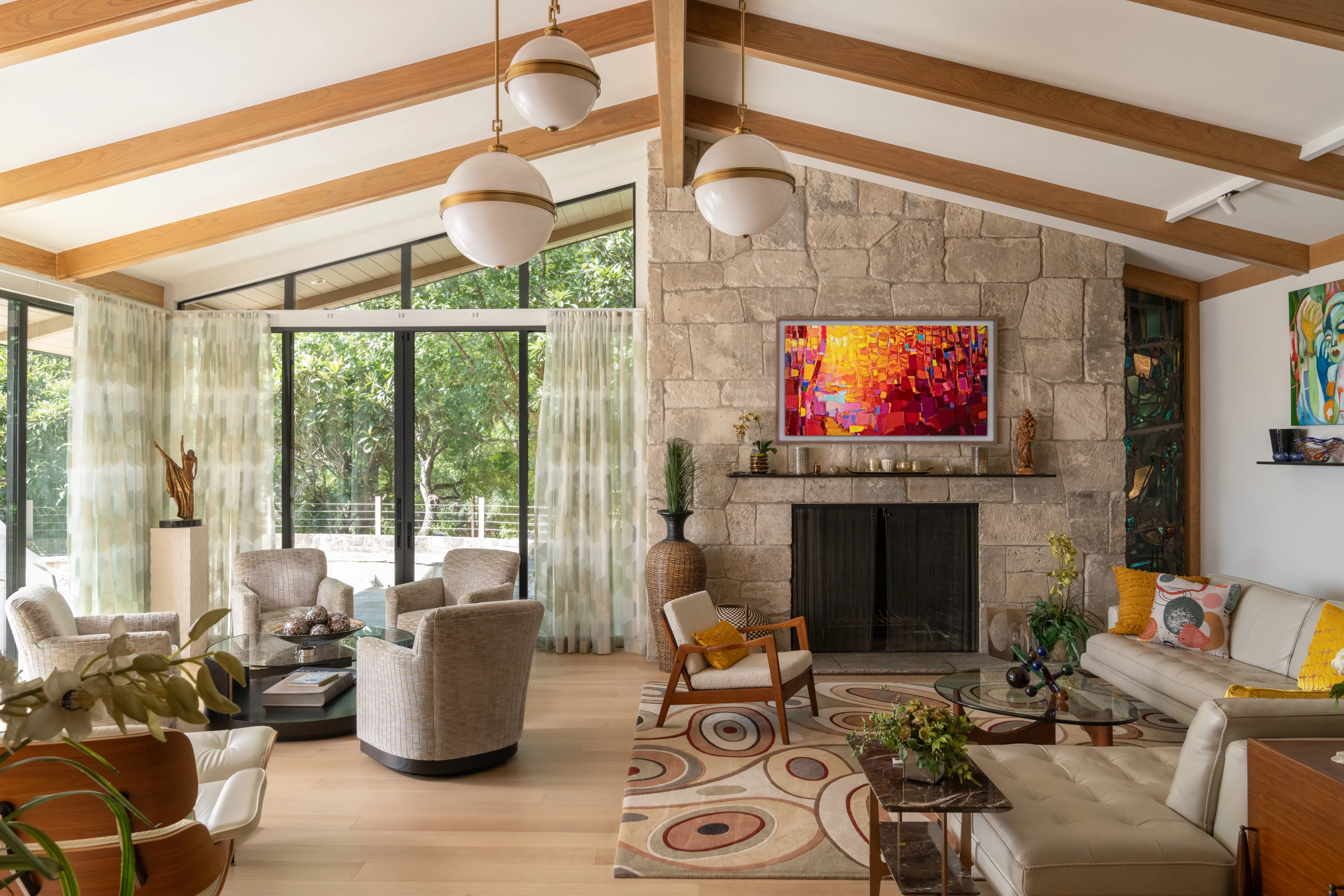 Living room under a vaulted timber ceiling with a stone fireplace