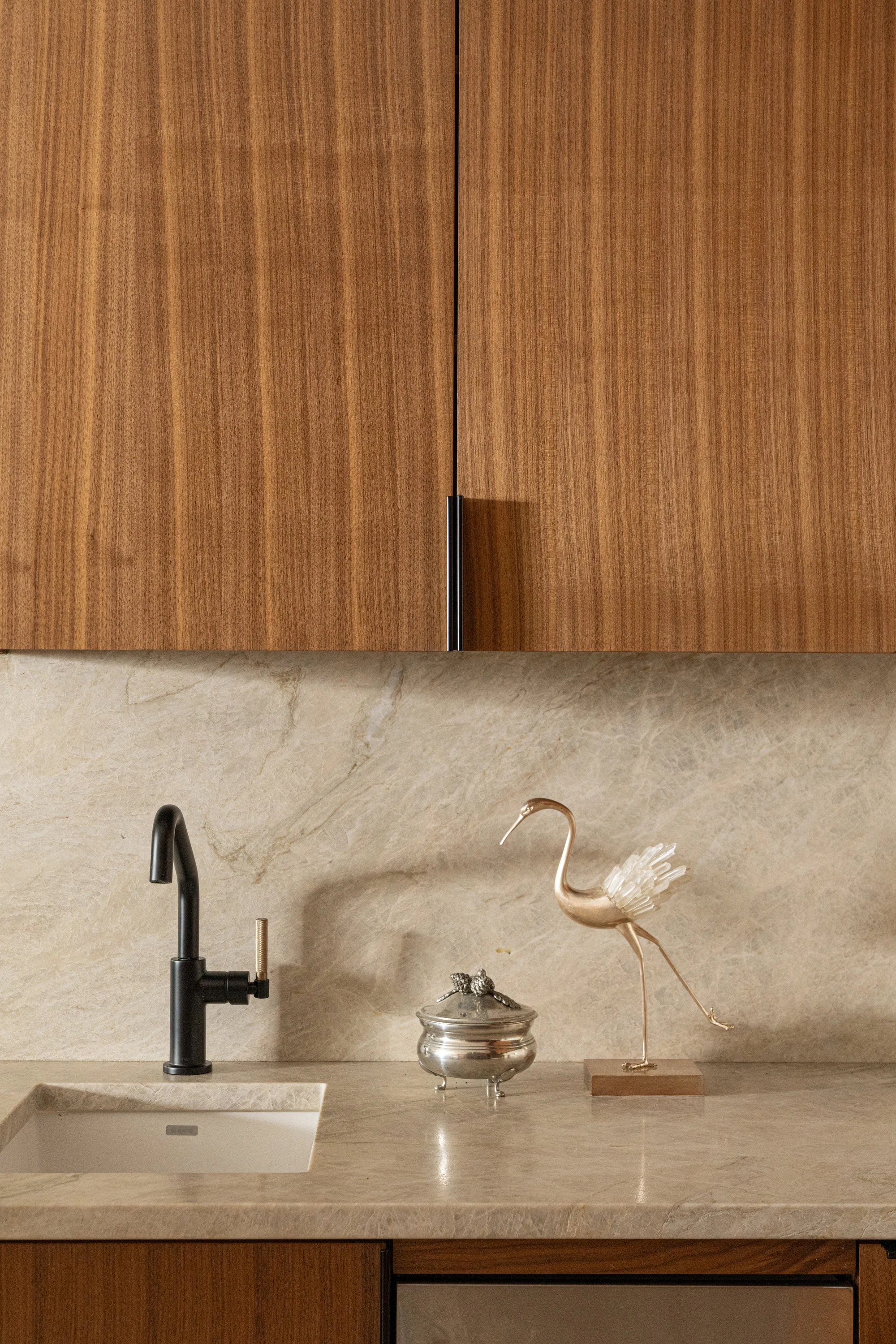 Taj Mahal counter and sink with a brass tap and a bird sculpture